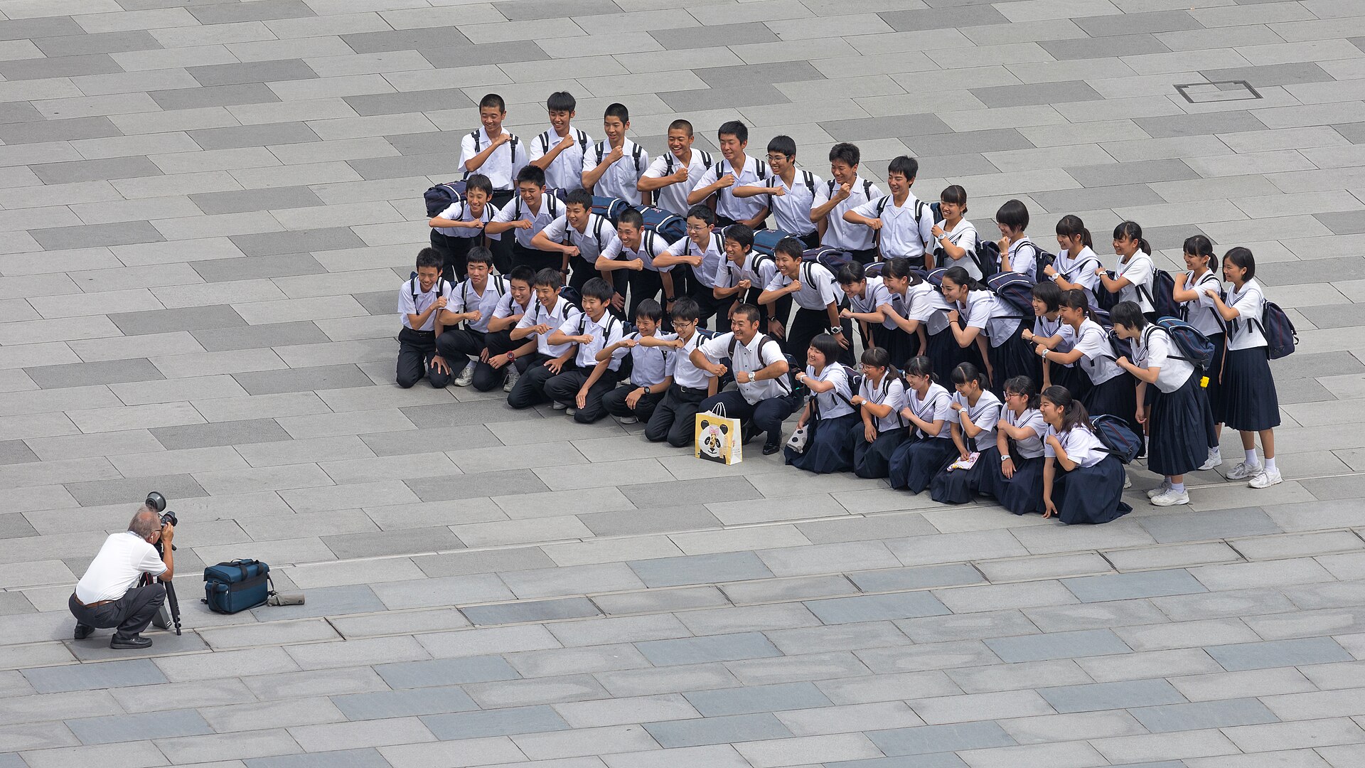 File:Photographer taking a group photograph of smiling students in front of the Tokyo station, Marunouchi, Japan.jpg